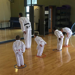 Young taekwondo students bowing in class showing respect and discipline